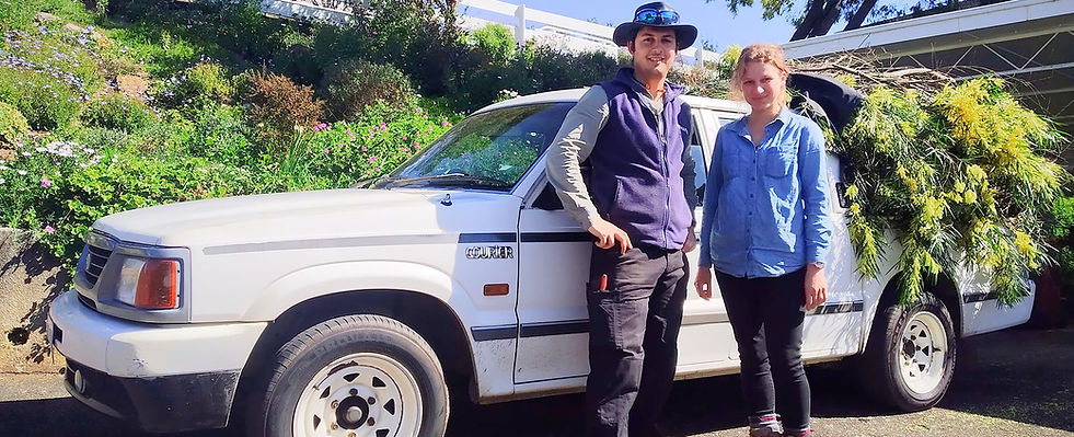 Mark and Leah standing beside their garden maintenance ute